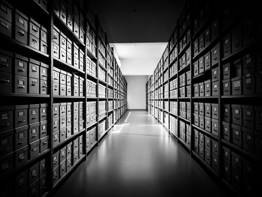 Infotraq Documents: long aisles of archive shelves and document boxes, in black and white